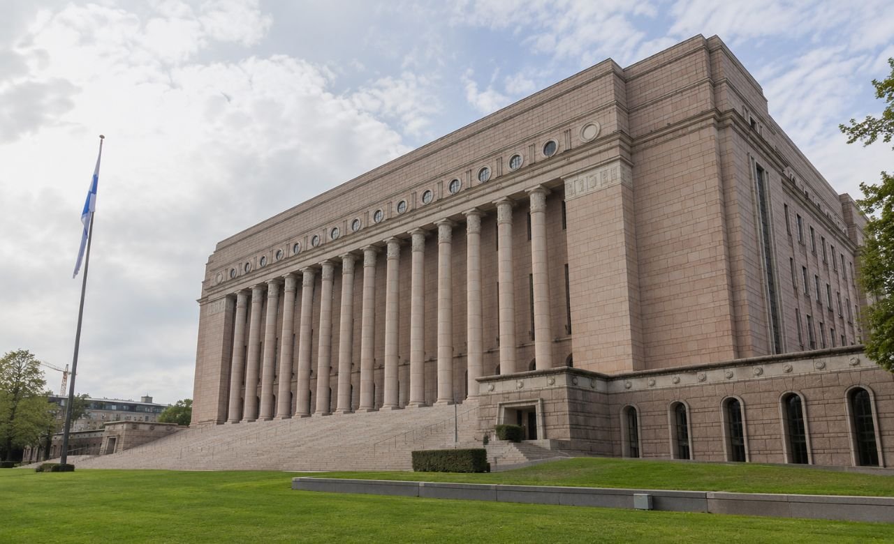 kuva Suomen eduskunnan rakennuksesta Helsingissä päivänvalossa.