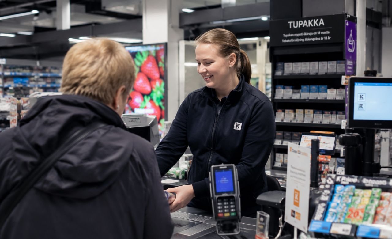kuva suomalaisesta myyjästä asiakaspalvelutilanteessa modernissa myymälässä