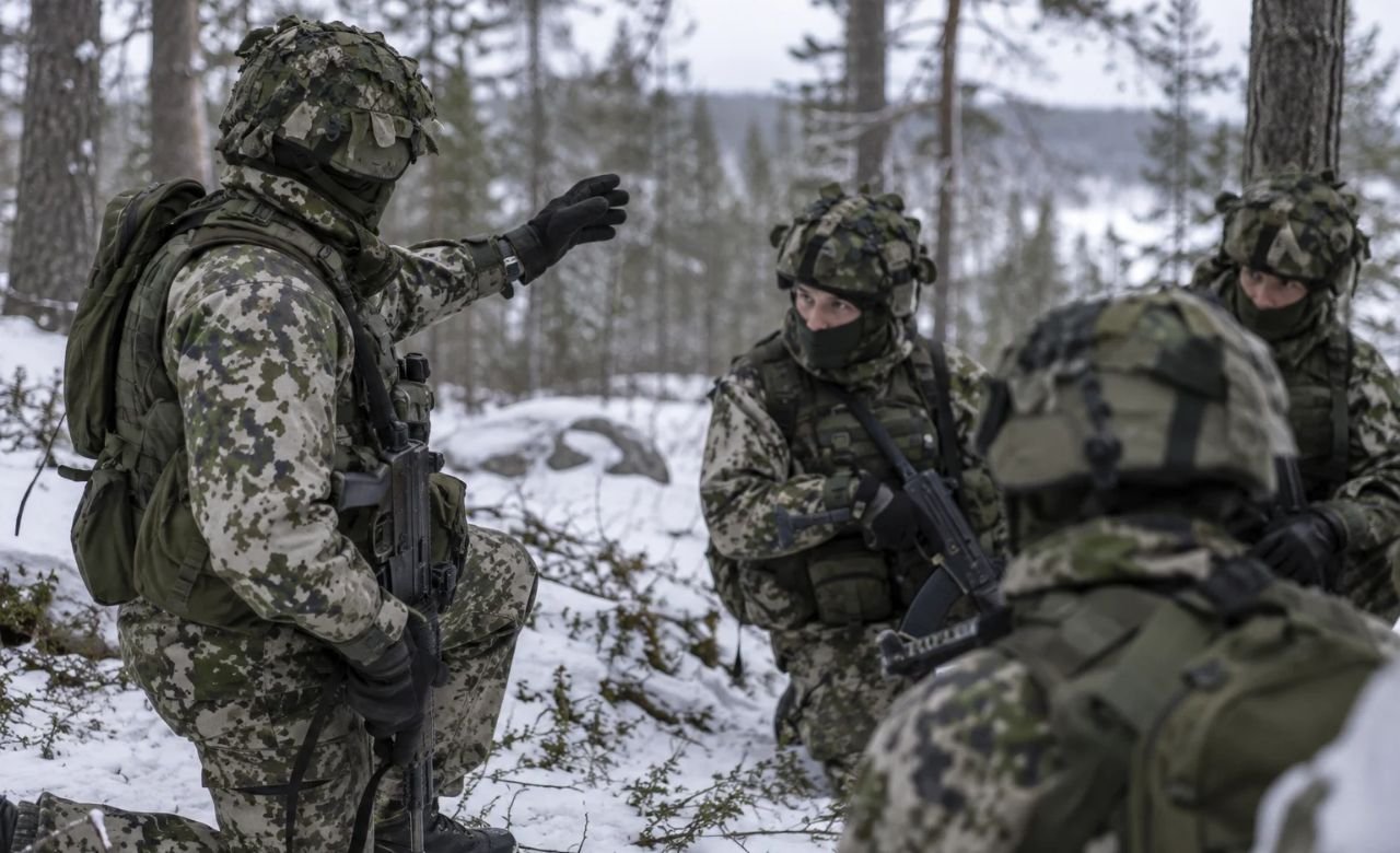 Aliupseeri kouluttamassa varusmiehiä maastossa